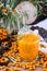 Syrup of seabuckthorn berries in a glass on a wooden table