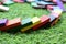 Systematic arrangement of multi colored wooden blocks on green grass