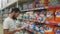 Syzran,Russia - July 20, 2019: Man looking on bottle of washing detergent in the mall and reading the label. Concept of