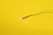 T-shaped intrauterine birth control device on yellow background