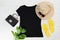 T shirt black and slippers. T-shirt Mockup flat lay with summer accessories. Hat, bag, yellow flip flops and sunglasses on wooden