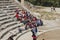 TA group of Asian tourists listens to a guide. On the stairs of the  ancient Epidauros theatre, Peloponnese, Greece,
