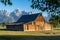 TA Moulton Barn at Mormon Row in Grand Teton National Park on a clear, sunny morning in summer. Natural framing by trees