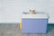 Tabby cat sitting on a pink top entry litter box.