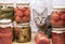 Tabby kitten among glass jars with pickled tomatoes, cucumbers and lecho. Ð¡oncept of home canning vegetables for the winter
