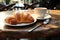 A table adorned with a flaky croissant and steaming coffee