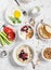 Table breakfast - cottage cheese with yogurt and berries, oatmeal with honey and berries, fried egg, fresh vegetables, homemade g