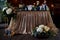 Table bride and groom at the wedding Banquet. Wedding floristry. Brown wooden screen.Tablecloth from simple tissue. Blue