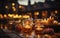 Table of candles on the terrace of the restaurant, blurred night city in the background.