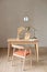 Table and chair in a modern style in beige colors with a vase of dried flowers and a copper lamp. Home Office. Interior Design