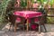 The table and chair set to relax in the garden above and the chair is made of rattan in brown and the table has red tablecloths