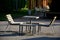 Table with chairs on a gravel surface as a part of a rest place in a city park construction metal seating areas are lined with