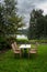 Table and chairs on lawn by lake on cold autumn day