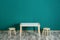 Table with chairs near turquoise wall in baby room interior