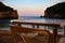 Table and chairs outdooe by the sea on the sunset. Twilight by the sea and mountains.