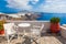 Table and chairs on roof with a panorama view on Santorini island, Greece.