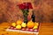 Table decorated with red rug, autumn flowers, bottle of wine, pumpkins and squashes