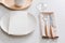 Table decoration. White plates, fork, knife on grey stone plate