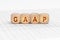 On the table with documents are wooden cubes with the inscription - GAAP
