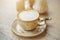 On the table is an elegant saucer and a cup, which is filled with a delicate cappuccino with a thick cream. A pleasant morning