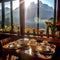 A table with elegantly arranged dishes against a background of mountain ranges visible outside the window