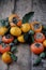 On the table a fresh persimmon, feijoa and citrus mandarins. Fruit wreath