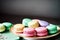 A table holds a platter adorned with an array of colorful macarons.