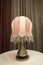 Table lamp, illuminated, classic art-deco style with brown curtain drapes behind