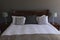 Table lamp and pillows arranged on a bed in bedroom