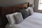 Table lamp and pillows arranged on a bed in bedroom