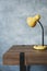 Table lamp at wooden table near concrete grey wall