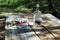 Table on the nature after a feast with an empty bottle and dried chamomiles