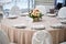 Table with a pink tablecloth, served and decorated with roses