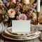 Table place with blank card on white wooden table with bohemian decorations close up. Boho wedding place card mockup.