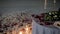 A table for a romantic dinner is decorated with candles and rose petals on ice in the middle of the stadium rink