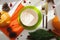 Table server with autumn composition. Cutlery, plate, pumpkin, red berries, cones and parsley on a wooden table in the