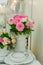 Table serving decorated with blooming pink roses. Home cozy celebration or party