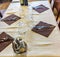 table set with beige tablecloth and brown napkins, glasses cutlery and ready-made condiments in an Italian restaurant