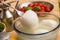 Table set with a bowl with buffalo mozzarella in the center and in the background the ingredients for the Mediterranean d