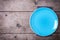 Table setting. Blue plate on grey napkin on vintage wooden background.