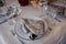 Table setting: brown napkin, knife and fork, wine glasses. Served for dinner in cozy restaurant