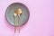 Table setting, Ceramic dishware, spoon and fork on pink pastel color background