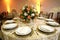 Table setting with cups, plates, napkins and food, flower arrangement in center with blurred background