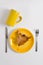 Table setting with dishes of autumn shades, yellow plate and yellow cup lay