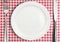 Table setting, empty plate and silverware on red towel, top view