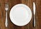 Table setting, empty plate and silverware on wooden table, top v