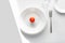Table setting example. white plates on a white background in the light of the sun. Tomato on a plate. place for text