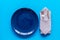 Table setting with plates and flatware on blue background top view