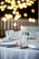 Table setting at a restaurant. Clean glass cup close up. Details of the banquet table. On the background blur are burning garlands