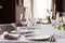 Table setting in the restaurant, glasses in the foreground. Luxury wedding reception. Flower arrangement on table in